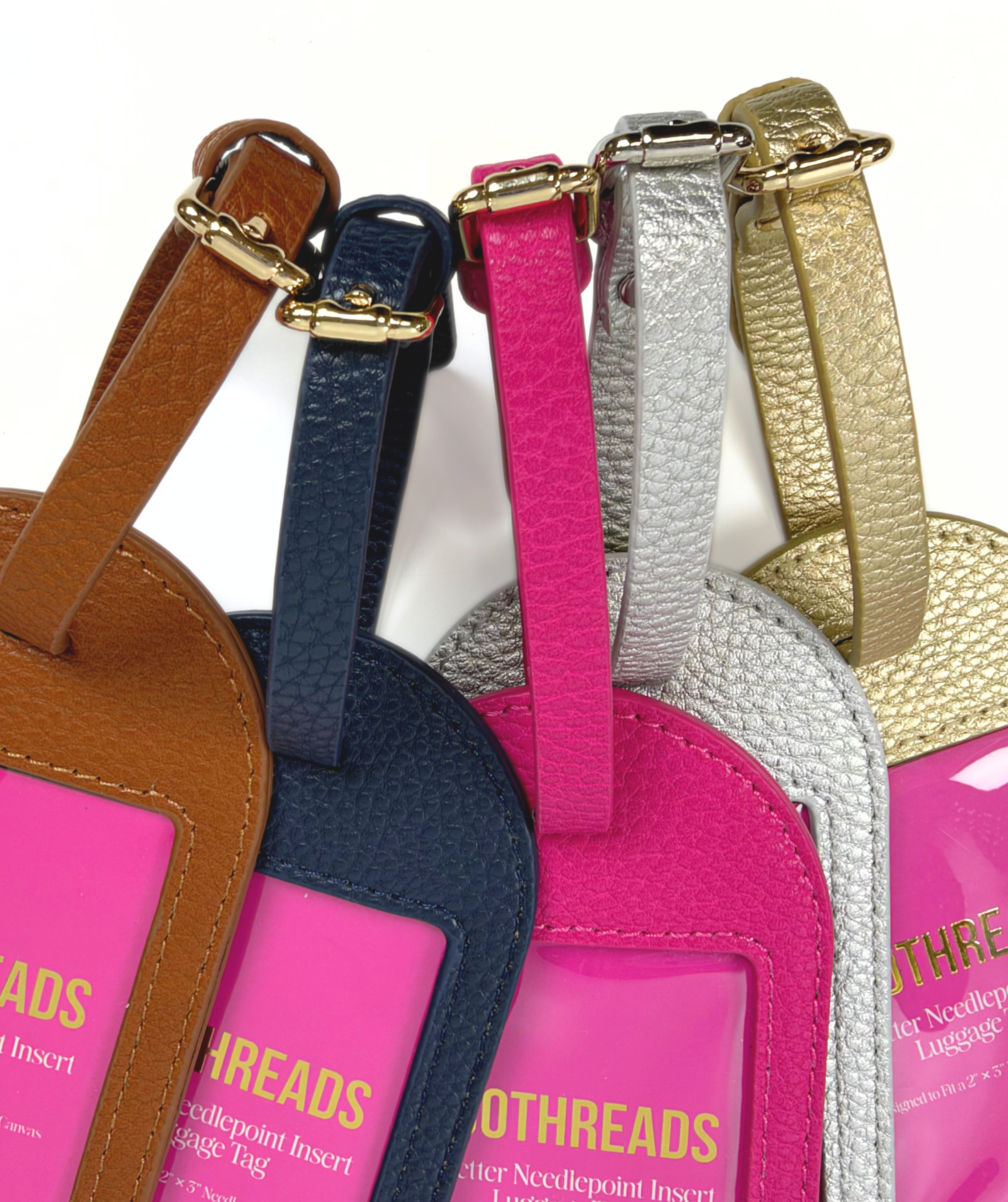 Close-up of adjustable buckle straps on Duo Threads needlepoint luggage tags in gold, silver, hot pink, navy, and brown.