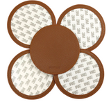 Brown self-finishing needlepoint coaster set featuring four round coasters with textured brown trim and removable circular inserts for needlepoint personalization.