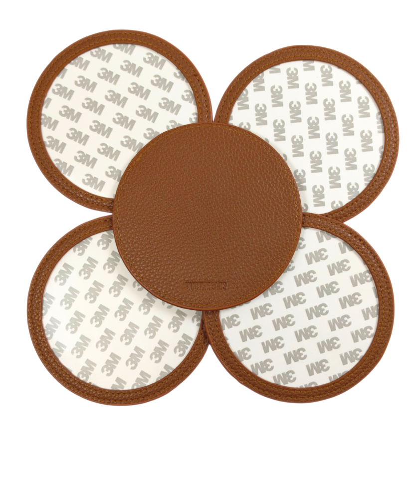 Brown self-finishing needlepoint coaster set featuring four round coasters with textured brown trim and removable circular inserts for needlepoint personalization.