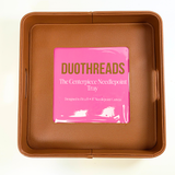 Brown self-finishing needlepoint valet tray featuring a square needlepoint insert window, structured sides, and textured finish.