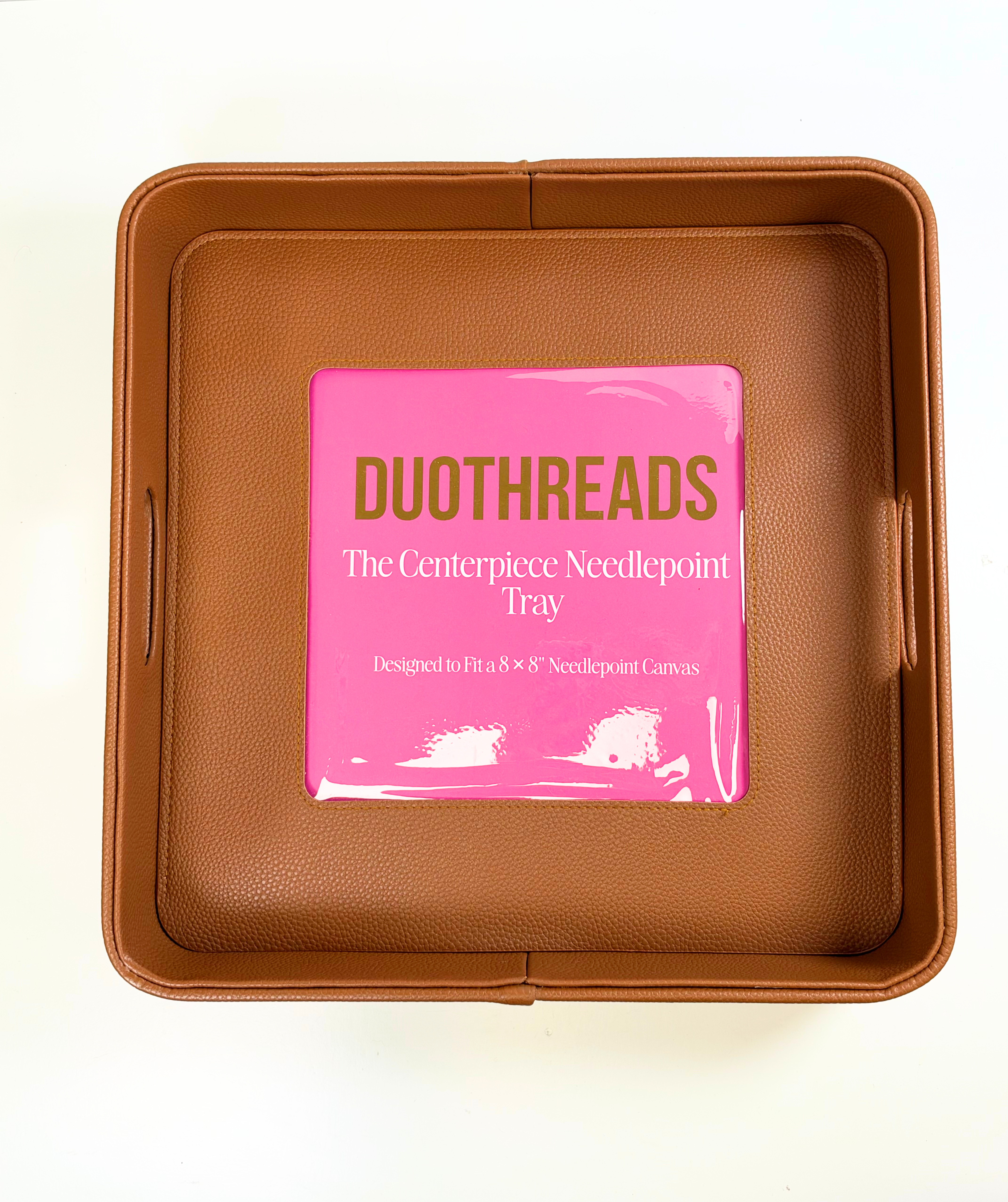 Brown self-finishing needlepoint valet tray featuring a square needlepoint insert window, structured sides, and textured finish.