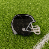 A black football helmet shaped claw clip on green turf background