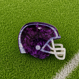 A purple football helmet shaped claw clip on green turf background