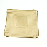 Gold metallic self-finishing needlepoint travel case featuring a textured exterior, zippered closure, and square needlepoint insert window.