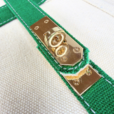 Detailed view of gold-tone turn-lock hardware and green trim on the Parker self-finishing needlepoint canvas boat tote.