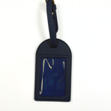 Navy blue self-finishing needlepoint luggage tag featuring a textured exterior, adjustable buckle strap, and rectangular needlepoint insert.
