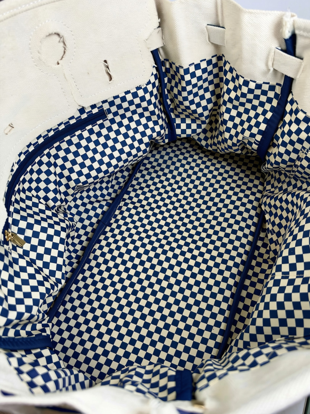 Inside view of the Parker needlepoint tote featuring navy blue and white gingham lining and roomy interior storage.