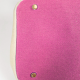 Close-up of the Parker needlepoint tote's pink bottom panel with protective gold metal feet and cream canvas trim.