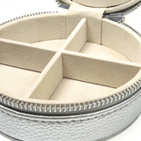 Close-up of silver self-finishing needlepoint travel jewelry case showing soft-lined jewelry compartments and zippered exterior.