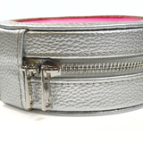 Close-up of silver metallic needlepoint travel jewelry case featuring textured material, silver zipper hardware, and compact round design.