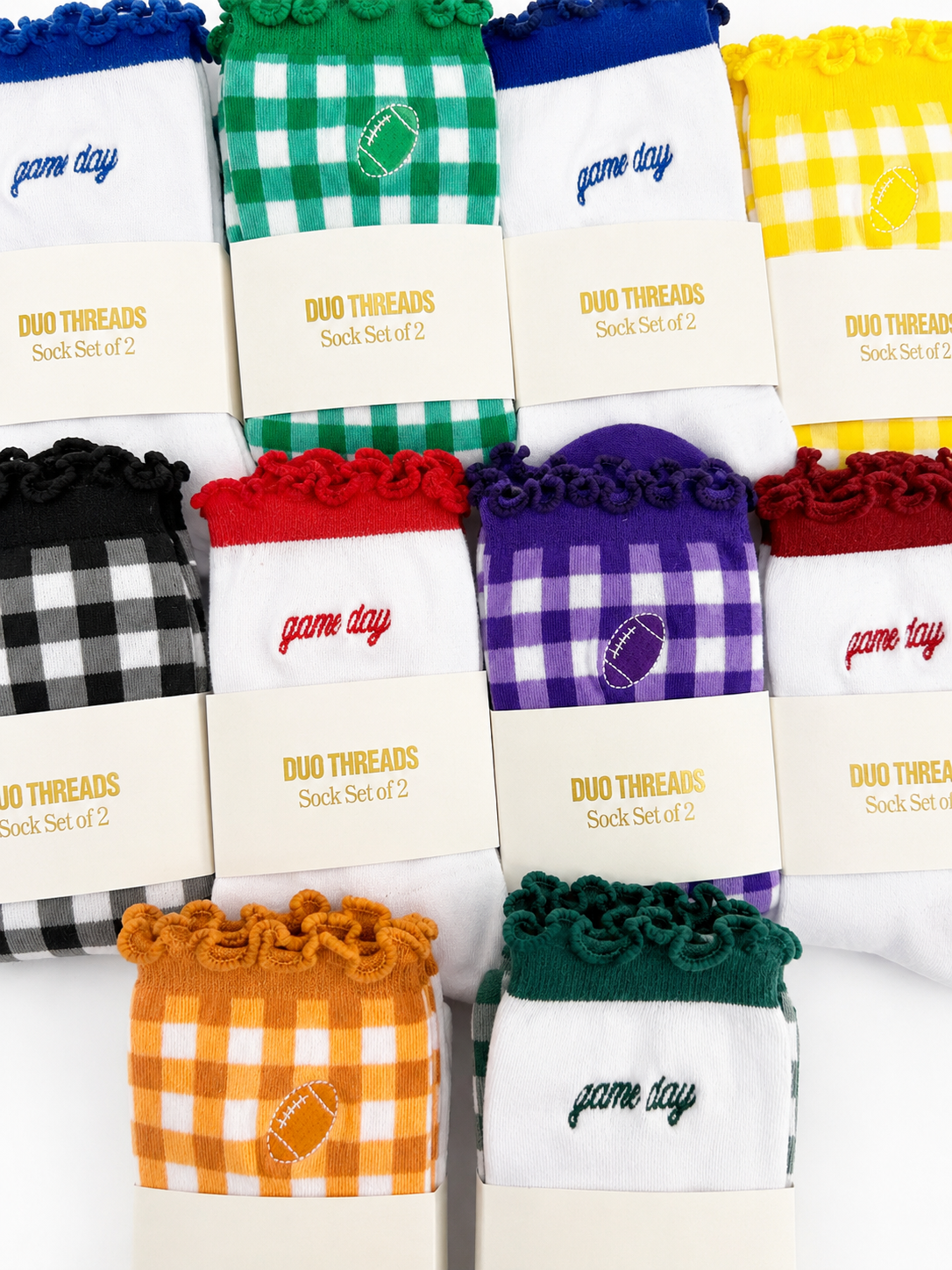 Eight pairs of sock sets arranged in a grid, each with a branded cream paper sleeve reading 'DUO THREADS Sock Set of 2'. The socks feature different colorways including green-and-white gingham, blue-and-white gingham, yellow-and-white gingham, black-and-white gingham, red-and-white gingham, purple-and-white gingham, orange-and-white gingham, and dark green-and-white gingham.